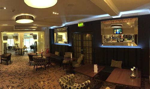 a restaurant with tables and chairs and a bar at Ivy Hill Hotel, Sure Hotel Collection by Best Western in Chelmsford