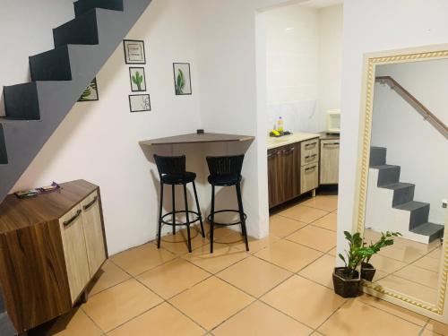 a kitchen with a counter and stools in a room at TuRiStAnDo eM fLoRiPa in Florianópolis