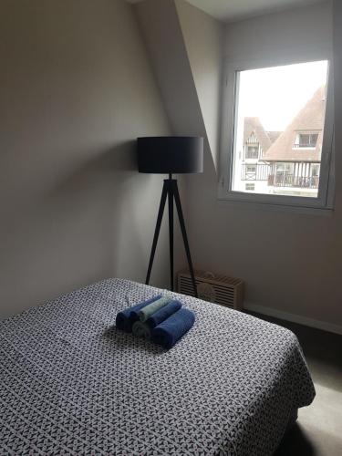 une chambre avec un lit avec une serviette bleue dessus dans l'établissement Appartement Liza 2 pièces Vue Mer à Cabourg, à Cabourg