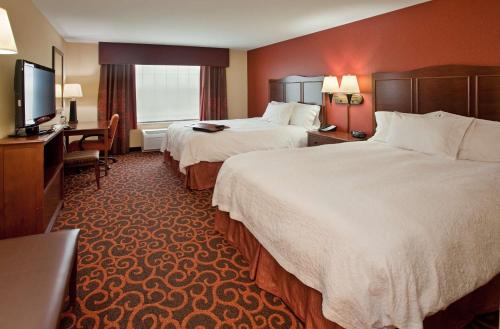 a hotel room with two beds and a flat screen tv at Hampton Inn & Suites Aberdeen in Aberdeen