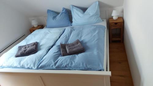 ein Bett mit blauer Bettwäsche und zwei Kissen darauf in der Unterkunft Casa Luna in Donnerskirchen