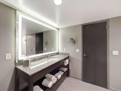 a bathroom with a sink and a large mirror at DoubleTree by Hilton Bloomington in Bloomington