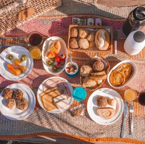 a table with many plates of food on it at Pico da Tribo Pousada in Imbituba