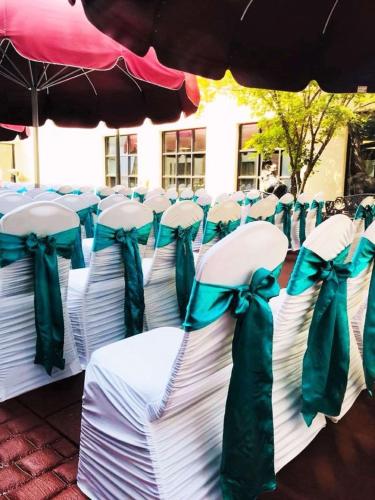 a group of chairs with bows sitting under an umbrella at DoubleTree by Hilton Bloomington in Bloomington