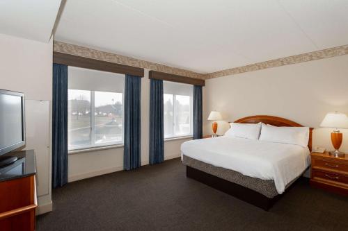 a hotel room with a bed and a flat screen tv at Hilton Garden Inn Wooster in Wooster