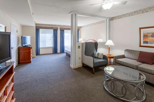 a hotel room with a couch and a tv and a living room at Hilton Garden Inn Wooster in Wooster
