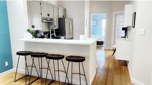 a kitchen with a counter and stools in it at Sunny Victorian with Stunning View and Wraparound Deck in San Francisco