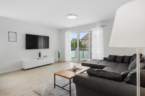 een woonkamer met een bank en een tafel bij WINETIME - modern - Boxspringbetten - Netflix - Nähe Mercedes-Benz in Wörth am Rhein