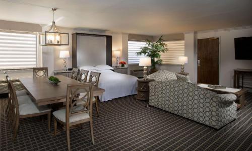 ノースブルックにあるHilton Chicago/Northbrookのベッド、テーブル、ソファが備わるホテルルームです。
