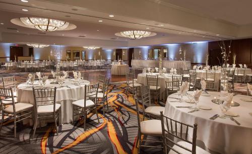 a banquet hall with white tables and chairs and chandeliers at Hilton Chicago/Northbrook in Northbrook