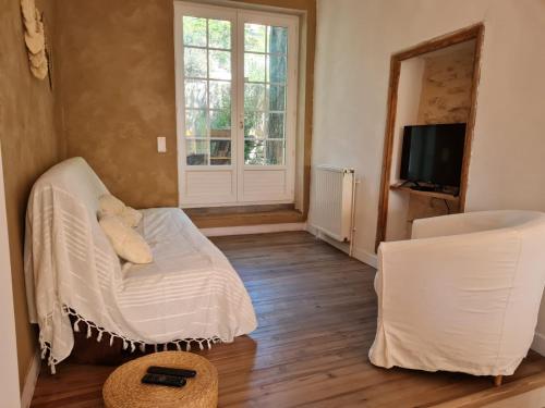 sala de estar con sofá blanco y TV en Maison provençale, jardin arboré et terrasses proche Grignan 8-10pers, en Réauville
