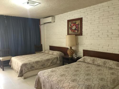 una habitación de hotel con 2 camas y una lámpara en Hotel las hamacas, en Acapulco