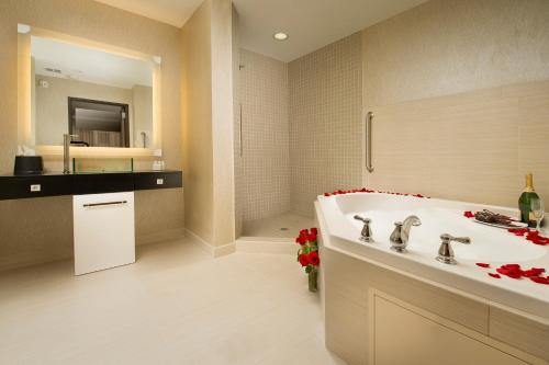 a bathroom with a tub and a sink and a mirror at TownePlace Suites by Marriott Dallas DFW Airport North/Grapevine in Grapevine