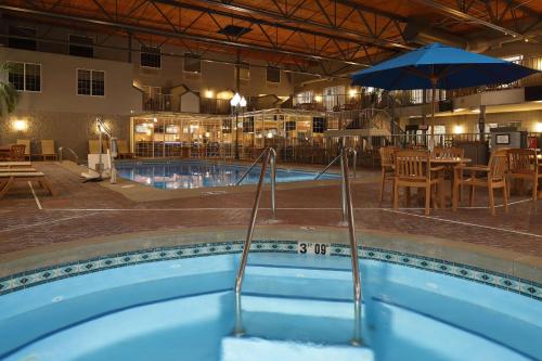 a swimming pool with an umbrella and a restaurant at Hampton Inn Holland in Holland