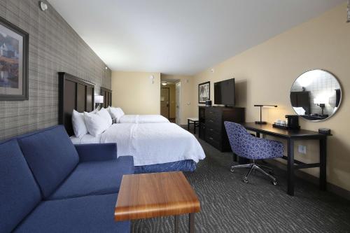 a hotel room with a bed and a desk and a couch at Hampton Inn Holland in Holland