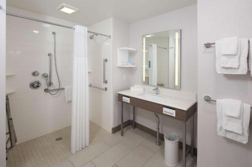 a white bathroom with a sink and a shower at Hampton Inn Holland in Holland
