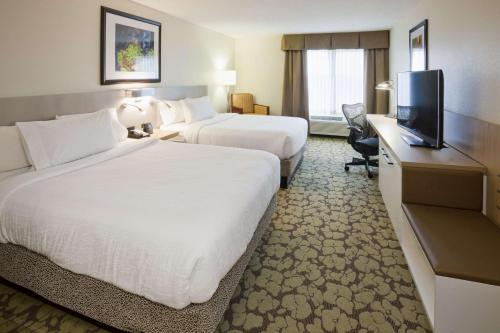 a hotel room with two beds and a flat screen tv at Hilton Garden Inn Minneapolis Eagan in Eagan