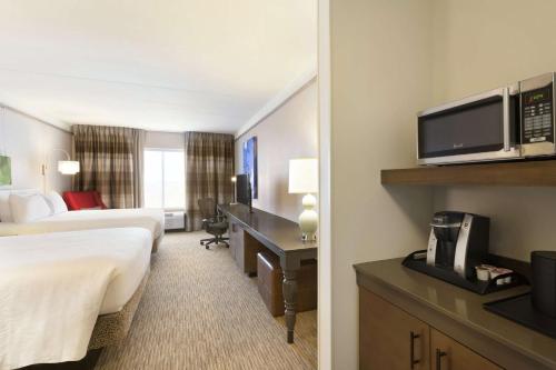 a hotel room with two beds and a television at Hilton Garden Inn Pittsburgh Airport South-Robinson Mall in Robinson Township