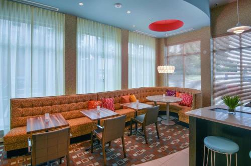 a restaurant with a couch and tables and chairs at Hilton Garden Inn Raleigh/Crabtree Valley in Raleigh
