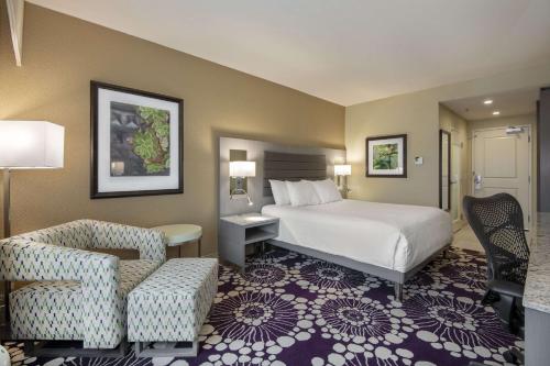 ローリーにあるHilton Garden Inn Raleigh/Crabtree Valleyのベッドと椅子付きのホテルルーム