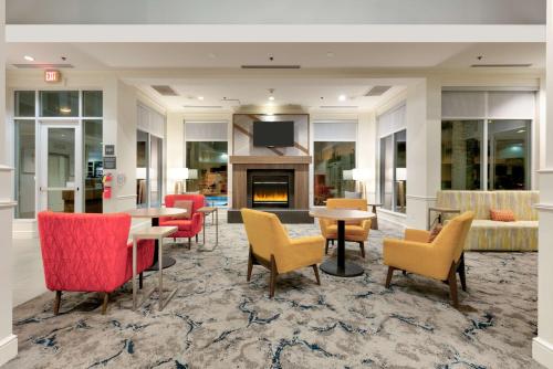 a lobby with tables and chairs and a fireplace at Hilton Garden Inn Irvine East/Lake Forest in Foothill Ranch