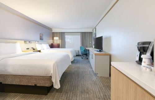 a hotel room with two beds and a television at Hilton Garden Inn Irvine East/Lake Forest in Foothill Ranch