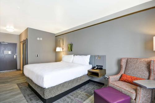 una camera d'albergo con letto e sedia di Hilton Garden Inn By Hilton Phoenix/Tempe Asu Area, Az a Tempe