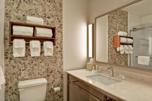 a bathroom with a toilet and a sink and a mirror at Hilton Garden Inn By Hilton Phoenix/Tempe Asu Area, Az in Tempe