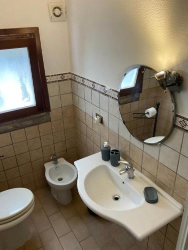 ein Badezimmer mit einem Waschbecken, einem WC und einem Spiegel in der Unterkunft Casadolu 
