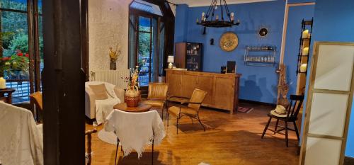a living room with blue walls and a table and chairs at Hotel ChezJeanne in La Bourboule