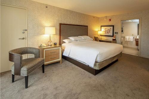 a hotel room with a bed and a chair at DoubleTree by Hilton Pittsburgh-Green Tree in Pittsburgh