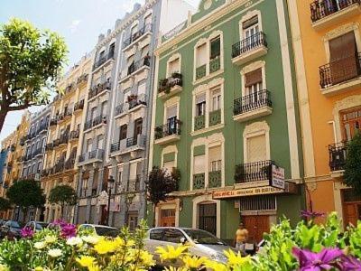 um edifício verde e branco com flores em frente em HABITACIÓN DOBLE o TRIPLE CORAZON DE RUZAFA em Valência