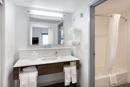 a bathroom with a sink and a mirror and a tub at Hampton Inn Acworth in Acworth