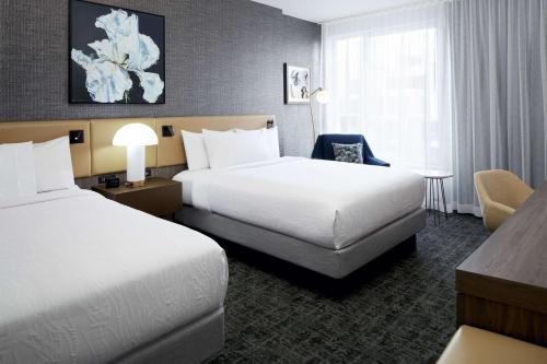 蒙特婁的住宿－Hilton Garden Inn Montreal Midtown, Quebec, Canada，酒店客房配有两张床和一张书桌