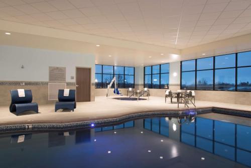 uma piscina num edifício com cadeiras e mesas em Hampton Inn & Suites Grand Rapids Downtown em Grand Rapids