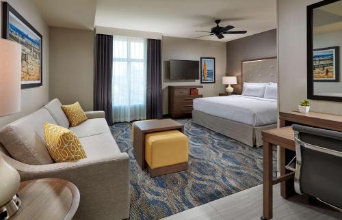 Homewood Suites By Hilton Los Angeles Redondo Beach في شاطئ ريدوندو: غرفه فندقيه بسرير واريكه