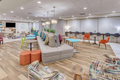 a lobby with a couch and tables and chairs at Home 2 Suites By Hilton Indianapolis Northwest in Indianapolis