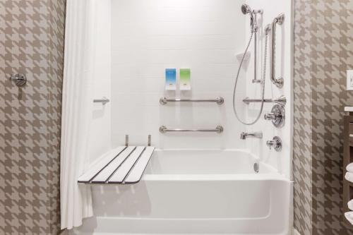 a bathroom with a white tub and a shower at Home 2 Suites By Hilton Indianapolis Northwest in Indianapolis