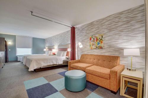 a hotel room with a bed and a couch at Home 2 Suites By Hilton Indianapolis Northwest in Indianapolis