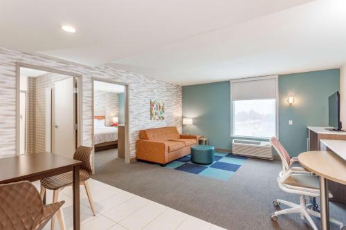 a living room with a couch and a table and chairs at Home 2 Suites By Hilton Indianapolis Northwest in Indianapolis
