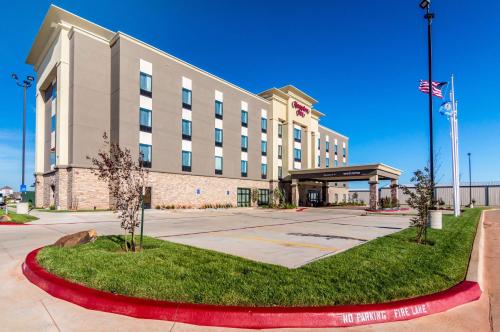 a hotel building with an american flag in front of it at Hampton Inn Oklahoma City Northeast OK in Oklahoma City