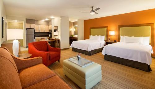 a hotel room with two beds and a living room at Homewood Suites by Hilton Winnipeg Airport - Polo Park in Winnipeg