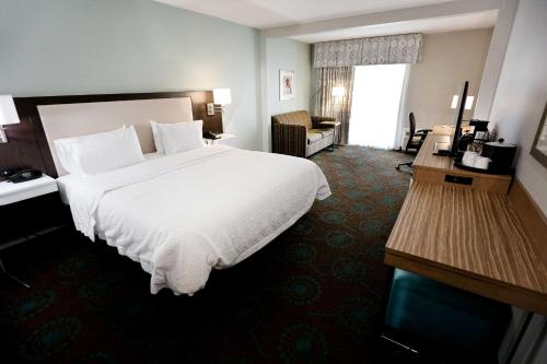 a hotel room with a large white bed and a window at Hampton Inn & Suites Chincoteague-Waterfront, Va in Chincoteague