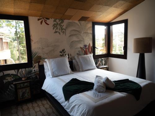 1 dormitorio con 1 cama blanca grande y ventanas en Les Alzines - Chalet con gran piscina cerca de Barcelona, en Òrrius