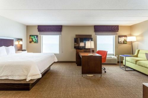 a hotel room with a bed and a couch at Hampton Inn & Suites Chicago - Libertyville in Libertyville