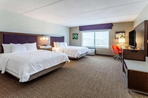 a hotel room with two beds and a flat screen tv at Hampton Inn & Suites Chicago - Libertyville in Libertyville