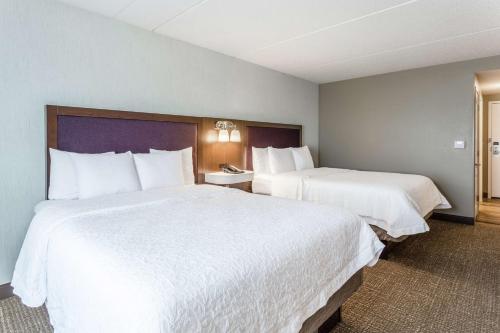 two beds in a hotel room with white sheets at Hampton Inn & Suites Chicago - Libertyville in Libertyville