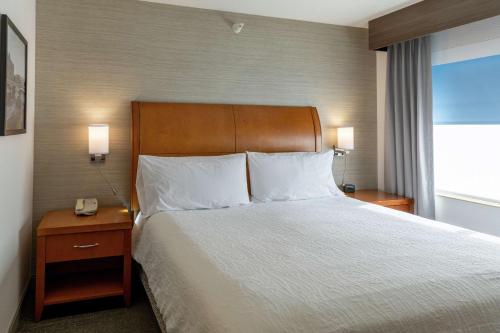 a hotel room with a bed and a phone on a table at Hilton Garden Inn West Des Moines in West Des Moines