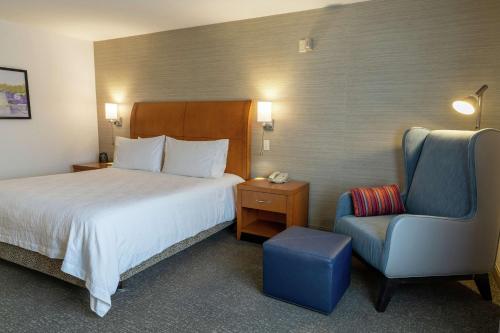 Habitación de hotel con cama y silla en Hilton Garden Inn West Des Moines, en West Des Moines