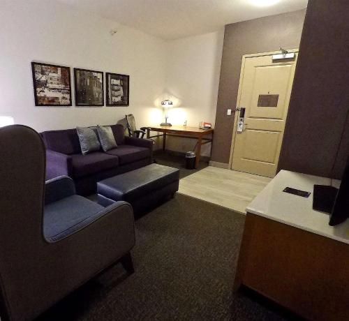 a living room with a couch and a chair and a table at Hilton Garden Inn West Des Moines in West Des Moines